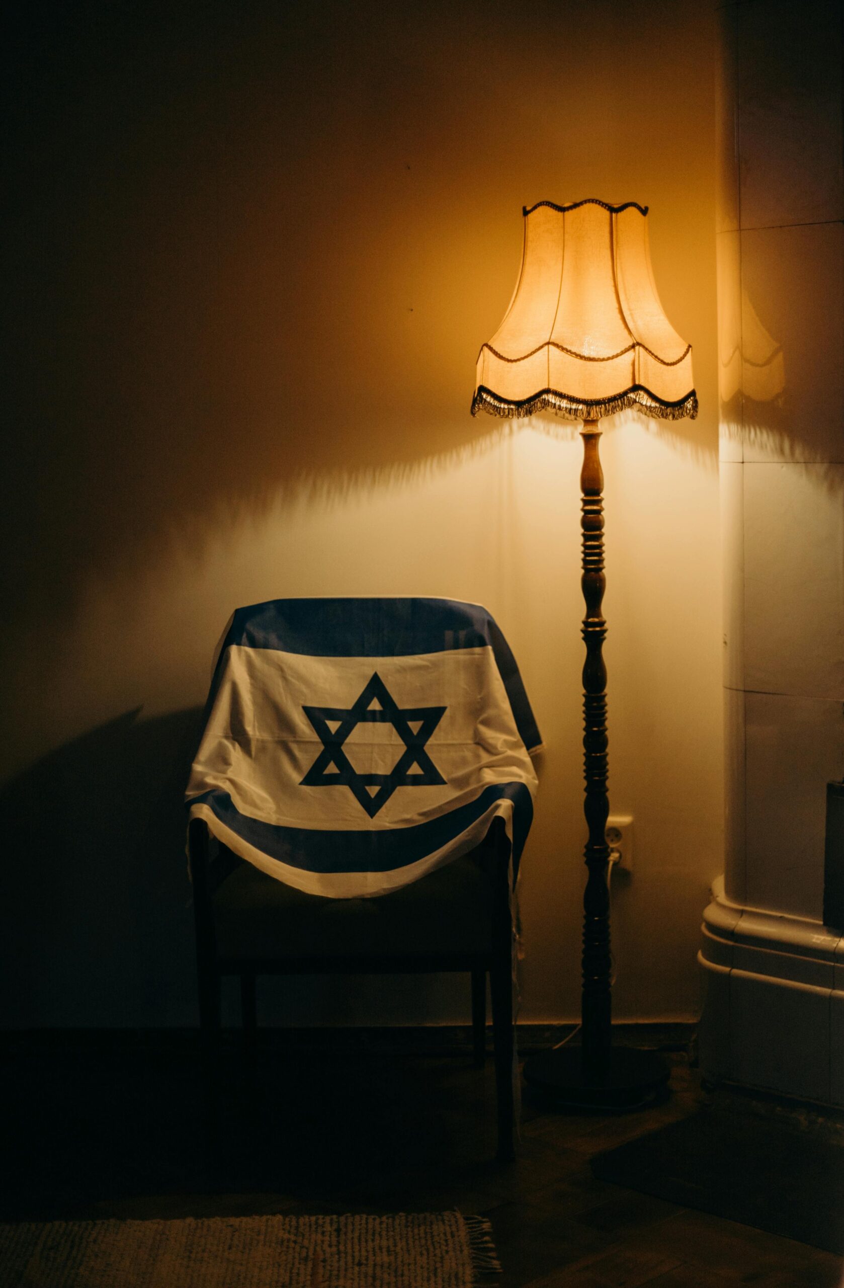 Current Global and U.S. News: Israel-Gaza Conflict, Epstein Fallout, and BMW Recall 1 Warmly lit room featuring an Israeli flag draped over an armchair.